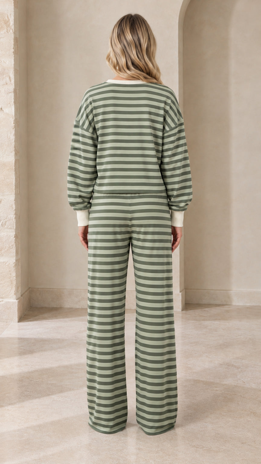 Back view of model wearing sage green striped loungewear set with wide leg trousers