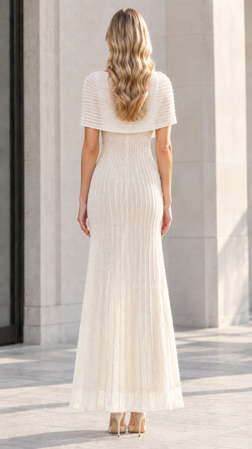 Back view of model wearing the Ivory embellished capelet maxi dress