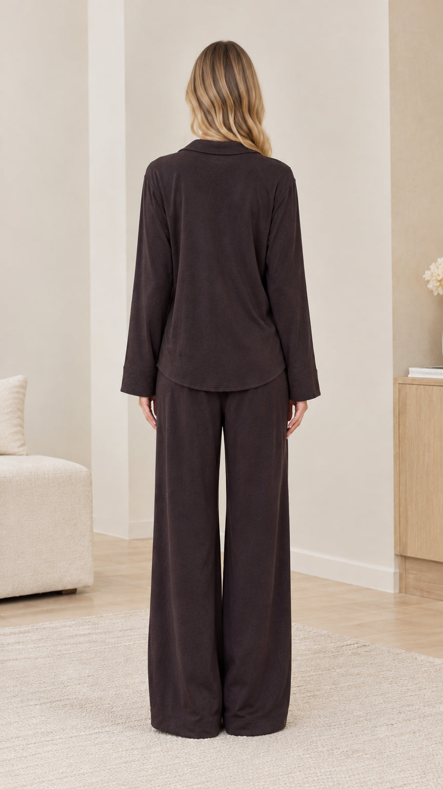 Back view of model wearing dark brown long sleeve loungewear set with wide-leg trousers