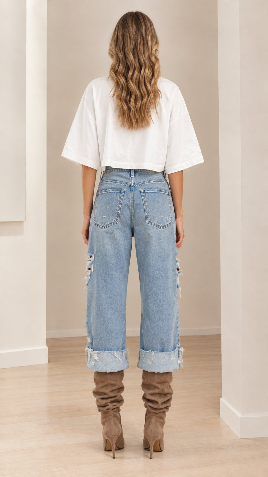 Model wearing white cropped tee and light blue cuffed jeans - back view