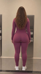 Back view of woman wearing mauve two-piece activewear jacket and leggings set