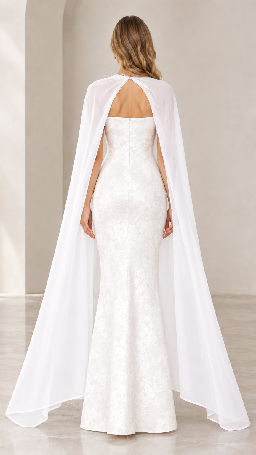 Back view of white strapless mermaid gown with keyhole cutout cape detail