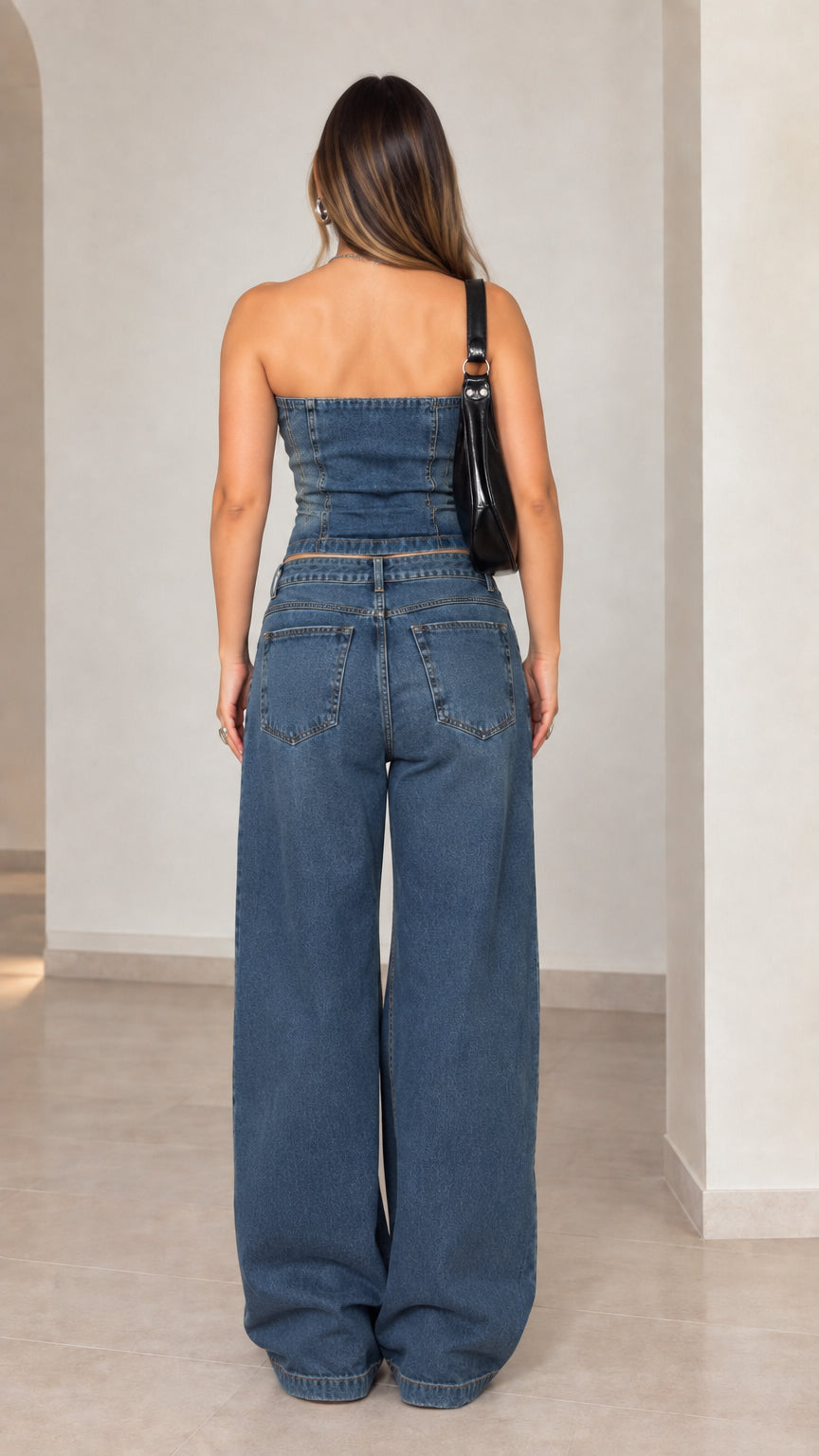 Back view of model wearing blue strapless denim co-ord set showing fitted back and pocket placement