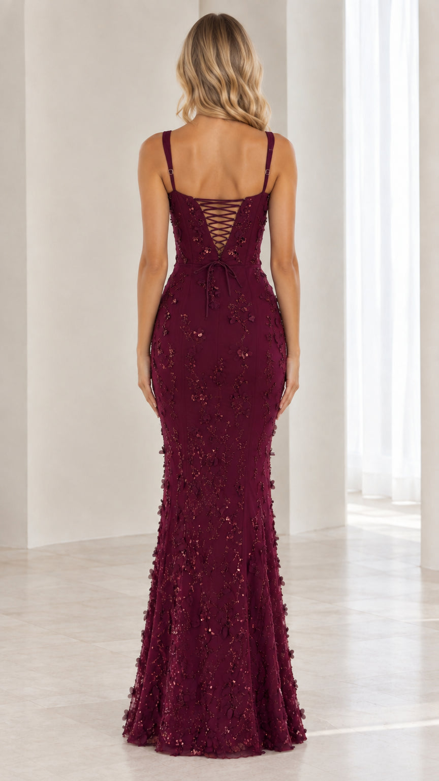 Back view of burgundy formal dress showcasing lace-up corset detail and mermaid flare