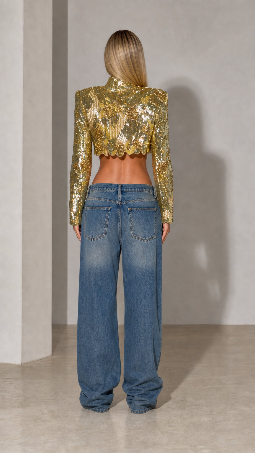 Back view of model in gold long sleeve cropped sequin top