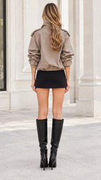 Back view of model wearing khaki cropped double-breasted trench jacket with cinched waist