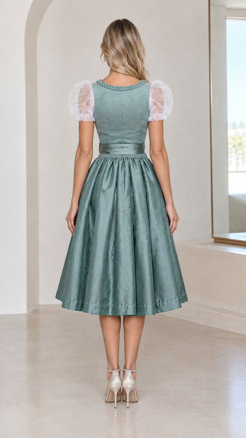 Back view of model wearing sage green dirndl dress showing neat back bodice and pleated skirt