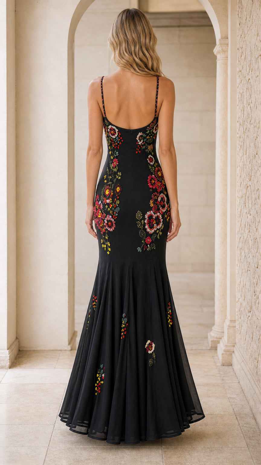 Back view of black floral embroidered gown showing low scoop back and flared skirt