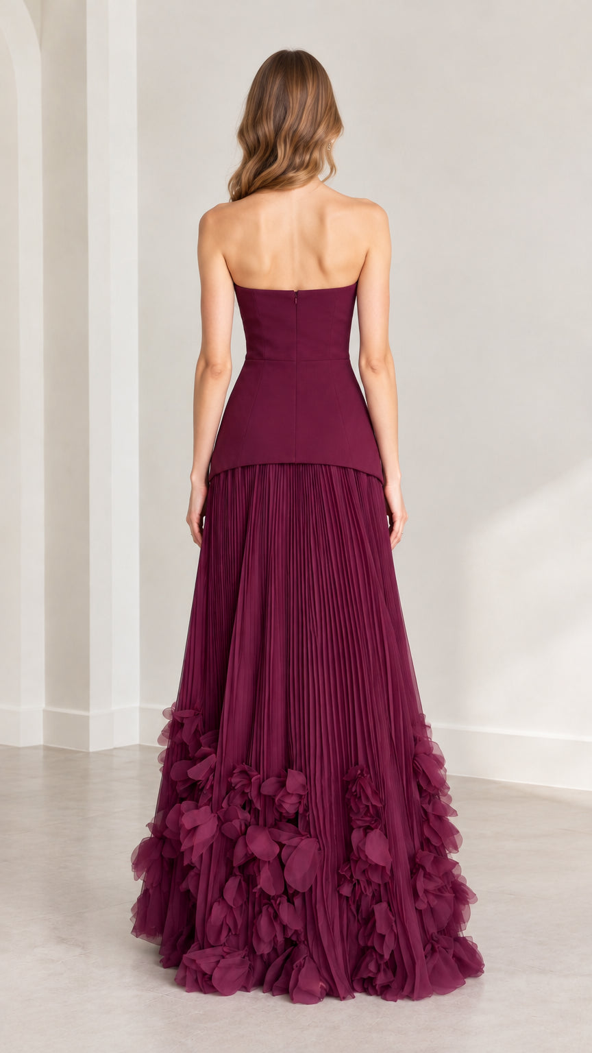 Back view of model wearing burgundy strapless gown with back zipper closure