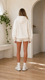 Model wearing cream oversized studded trim pullover hoodie back view