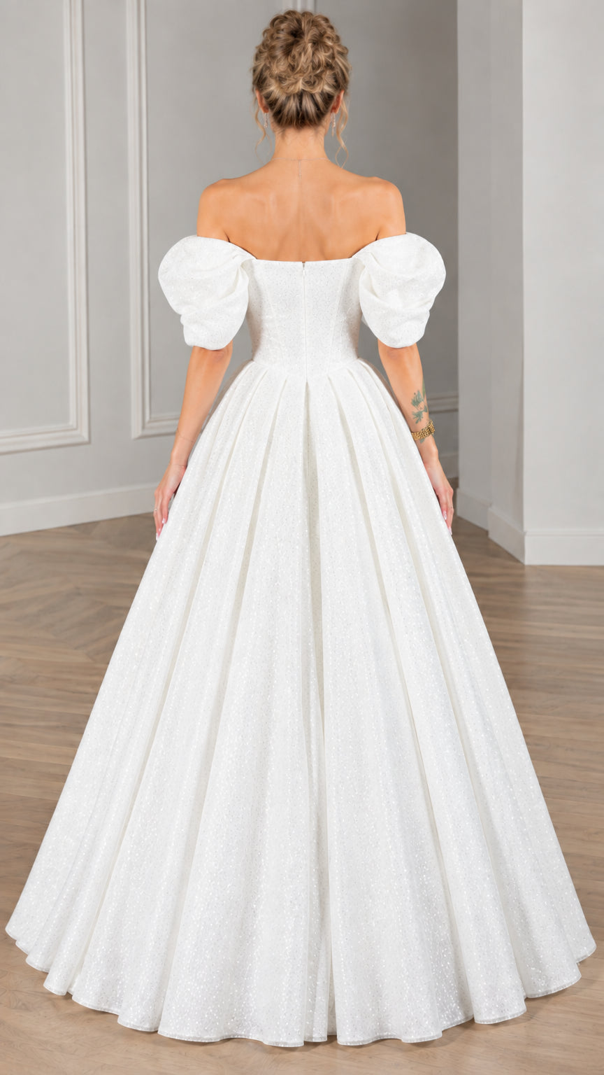 Back view of model wearing white puff-sleeve formal ball gown