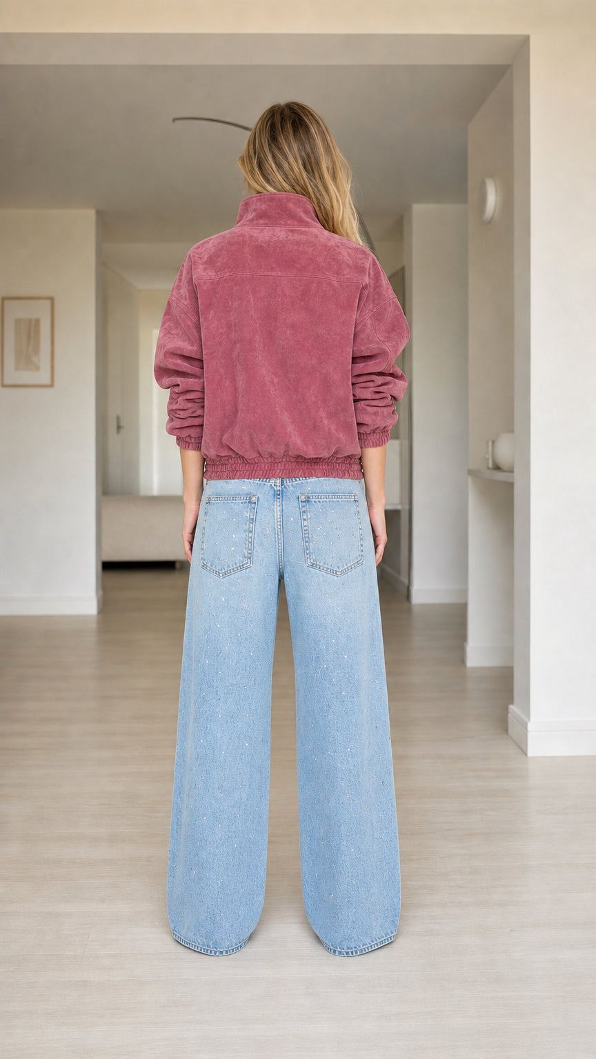Back view of model wearing dusty rose relaxed fit plush jacket with elastic hem