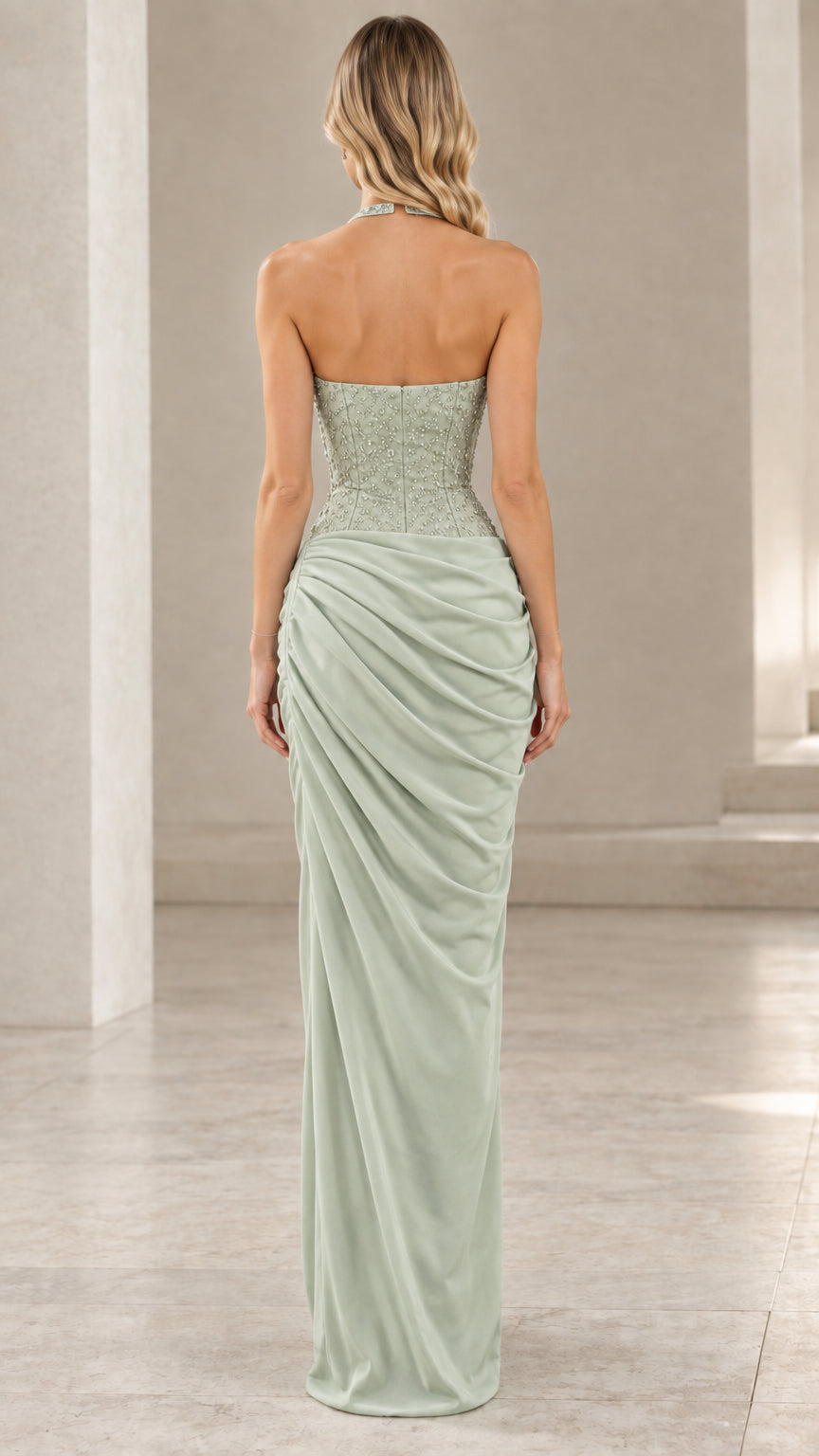 Back view of model in sage green halter corset evening dress highlighting the open back