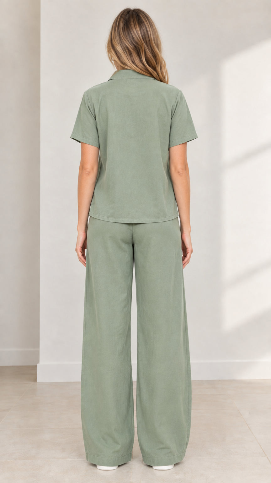 Back view of model wearing Sage Green button-up shirt and wide-leg matching trousers