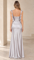 Back full-length view of model showcasing low back and back zipper on silver satin maxi dress
