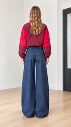 Back view of woman wearing burgundy and red color-block pullover jacket
