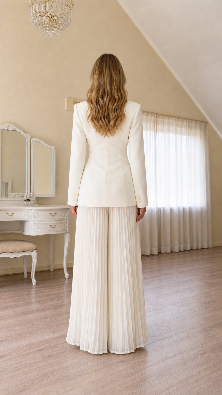 Back view of ivory tailored blazer and flowing pleated wide-leg trousers
