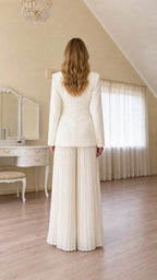 Back view of ivory tailored blazer and flowing pleated wide-leg trousers