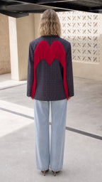 Back view of model showing red wing-shaped fringe across the Navy Plaid blazer