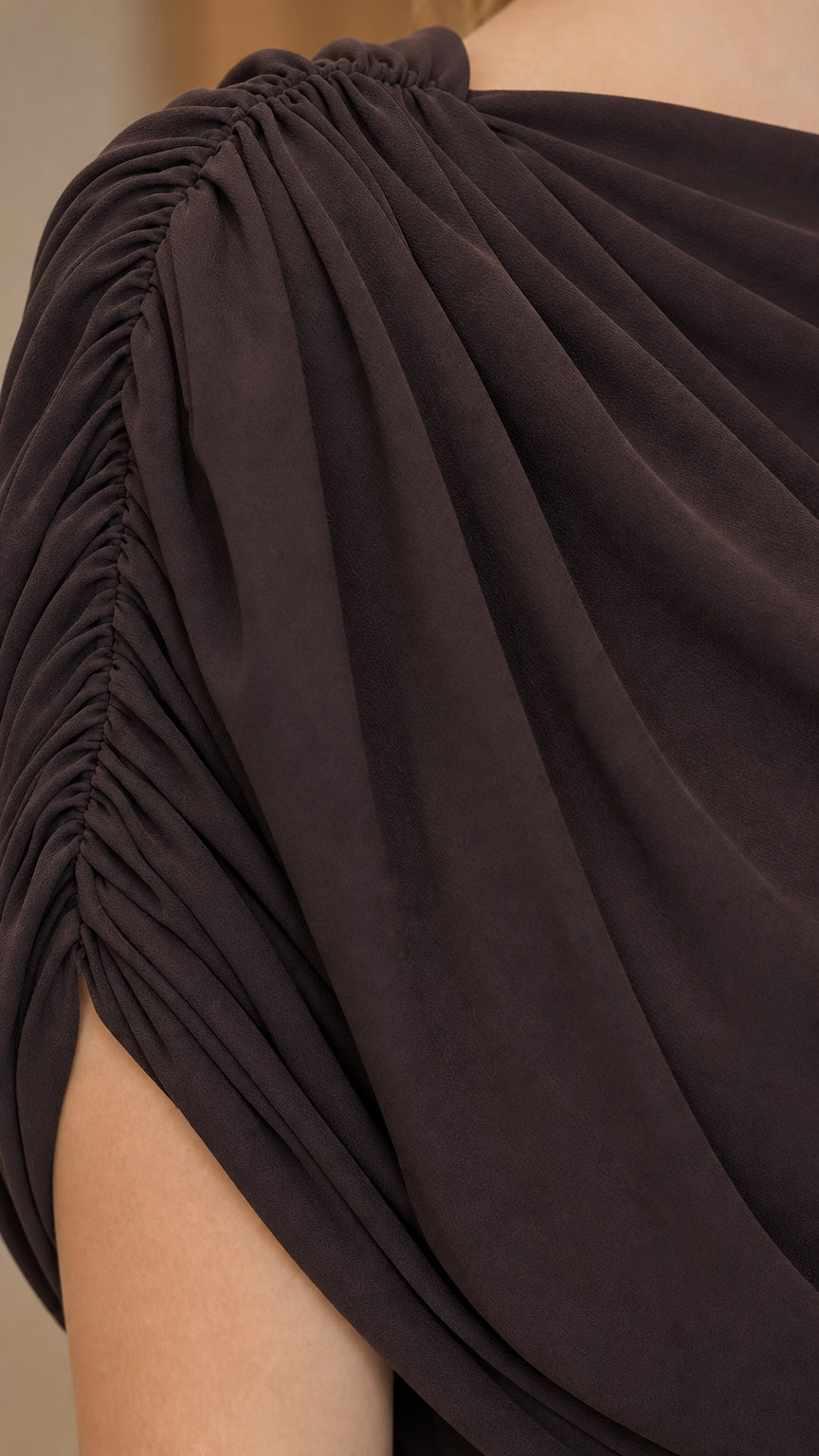 Close-up detail of gathered shoulder and soft draped fabric on evening dress