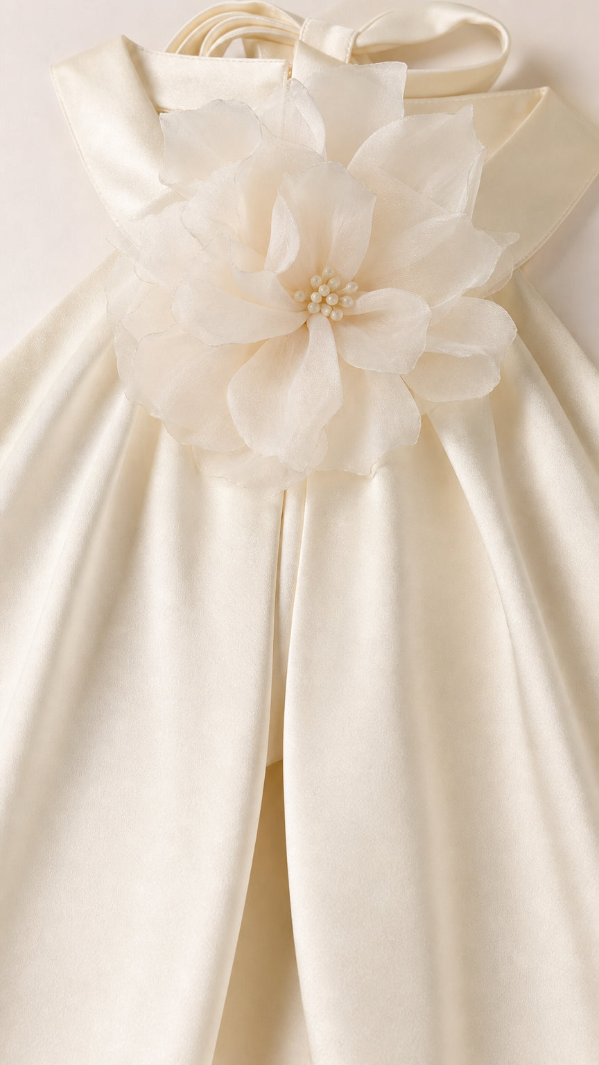 Close-up of 3D fabric flower applique on ivory halter neckline