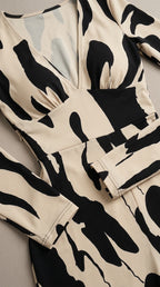 Bodice close-up of beige and black plunge V-neck jumpsuit with fitted waistband