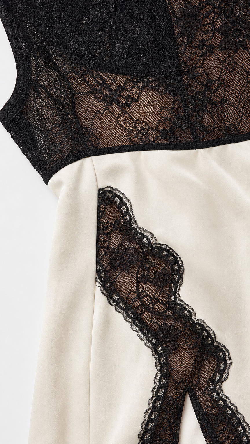 Close-up detail of black floral lace trim on ivory dress fabric