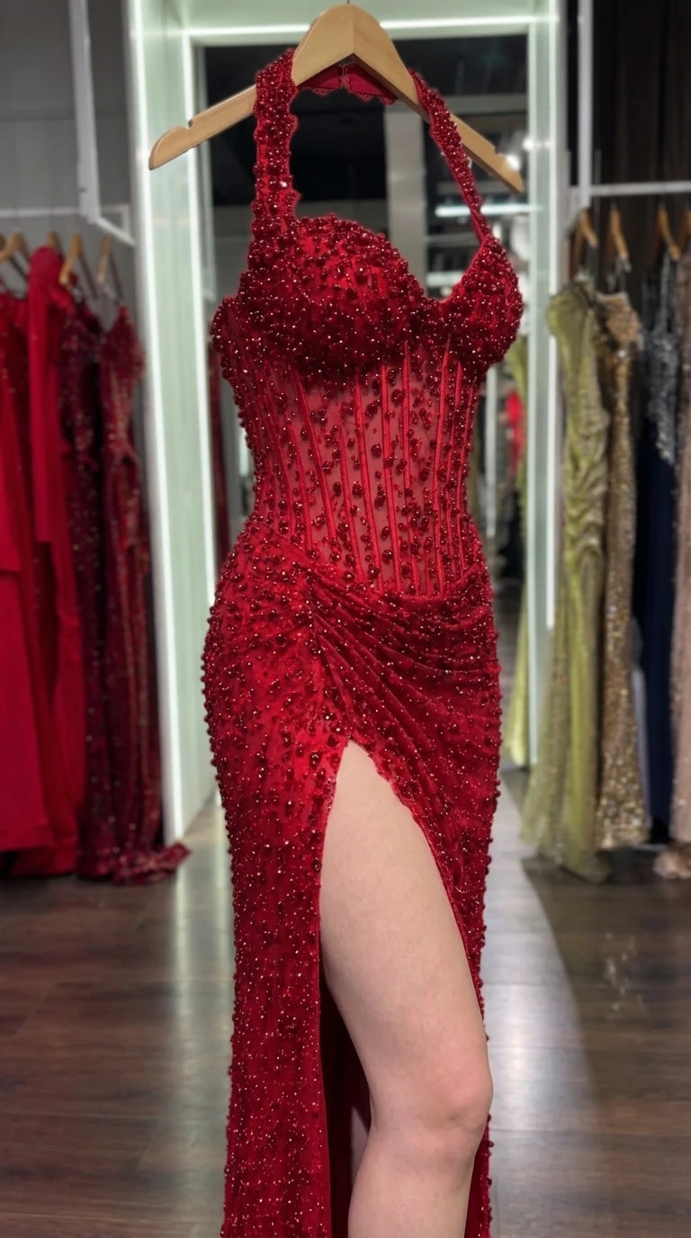 Close-up detail of the red corset evening gown bodice on a hanger showcasing boning and beadwork