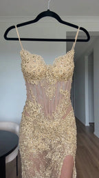 Close up view of gold corset evening dress with sweetheart beaded neckline on hanger