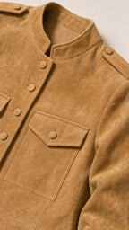Close-up detail of camel faux suede jacket collar, button closure, and flap chest pocket