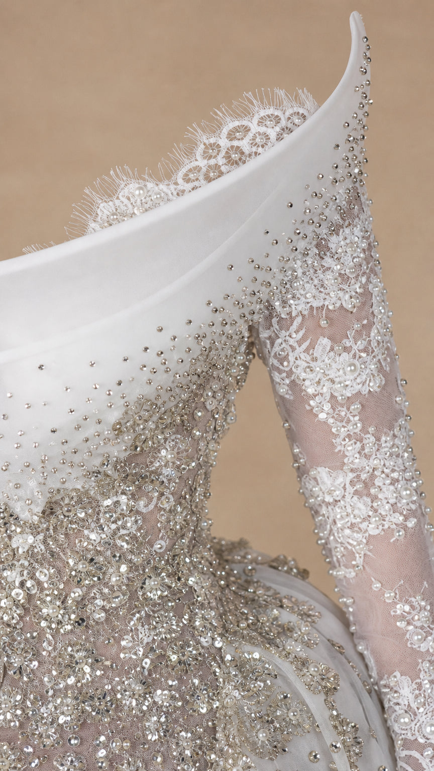 Close-up detail of white gown neckline with delicate lace edge and intricate crystal beadwork