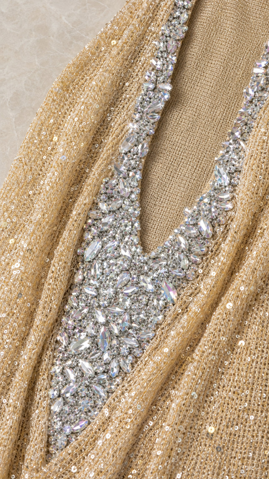 Close-up detail of rhinestone embellishments and metallic sequin fabric