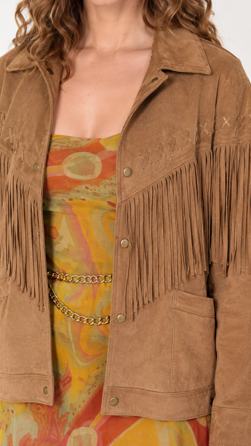 Close-up of tan faux suede texture, point collar, and fringe detailing