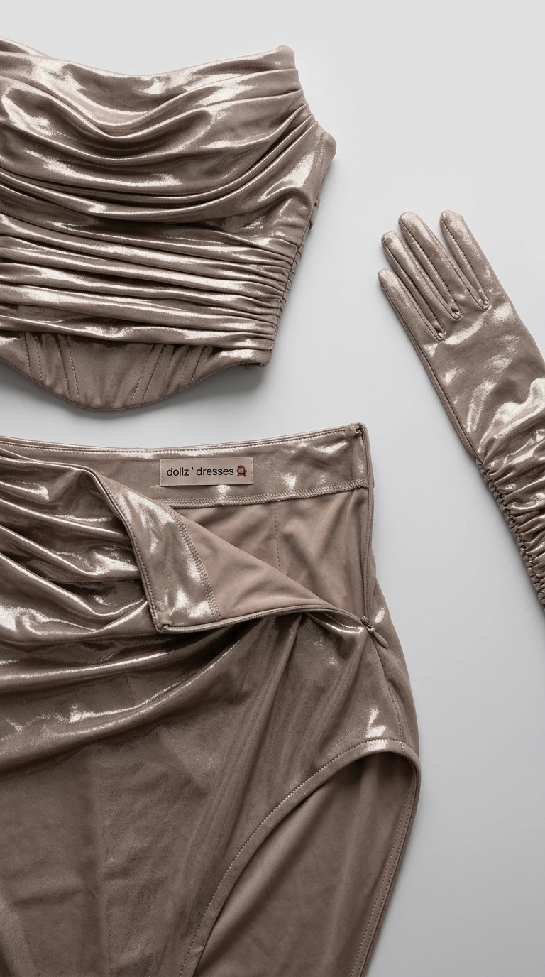 Flat lay close-up of champagne ruched corset top, side-slit maxi skirt, and evening glove