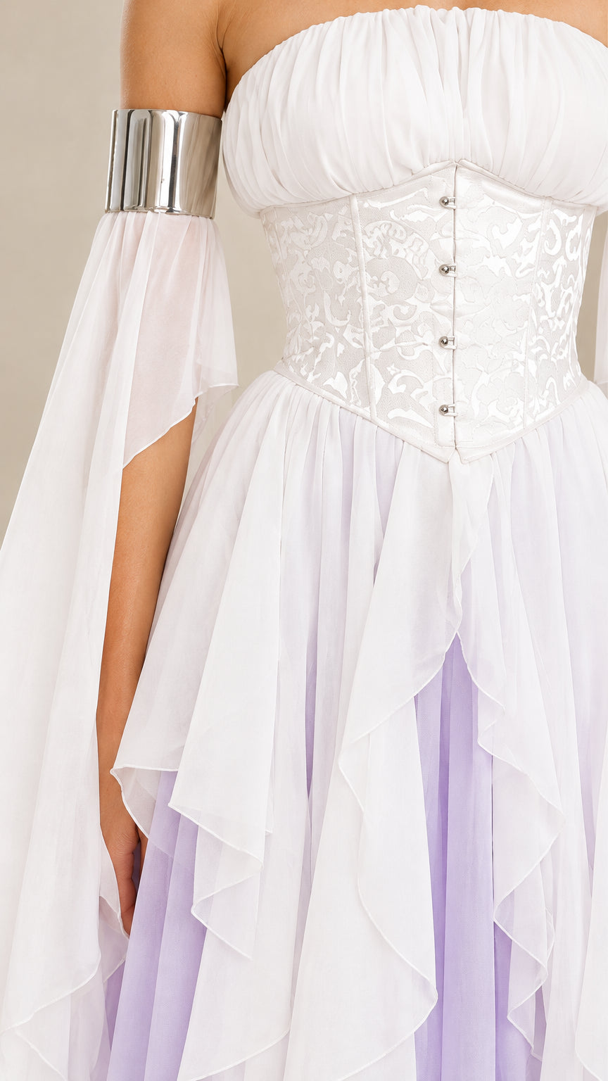 Close-up of the white corset bodice, metallic-look sleeve band, and layered ruffles