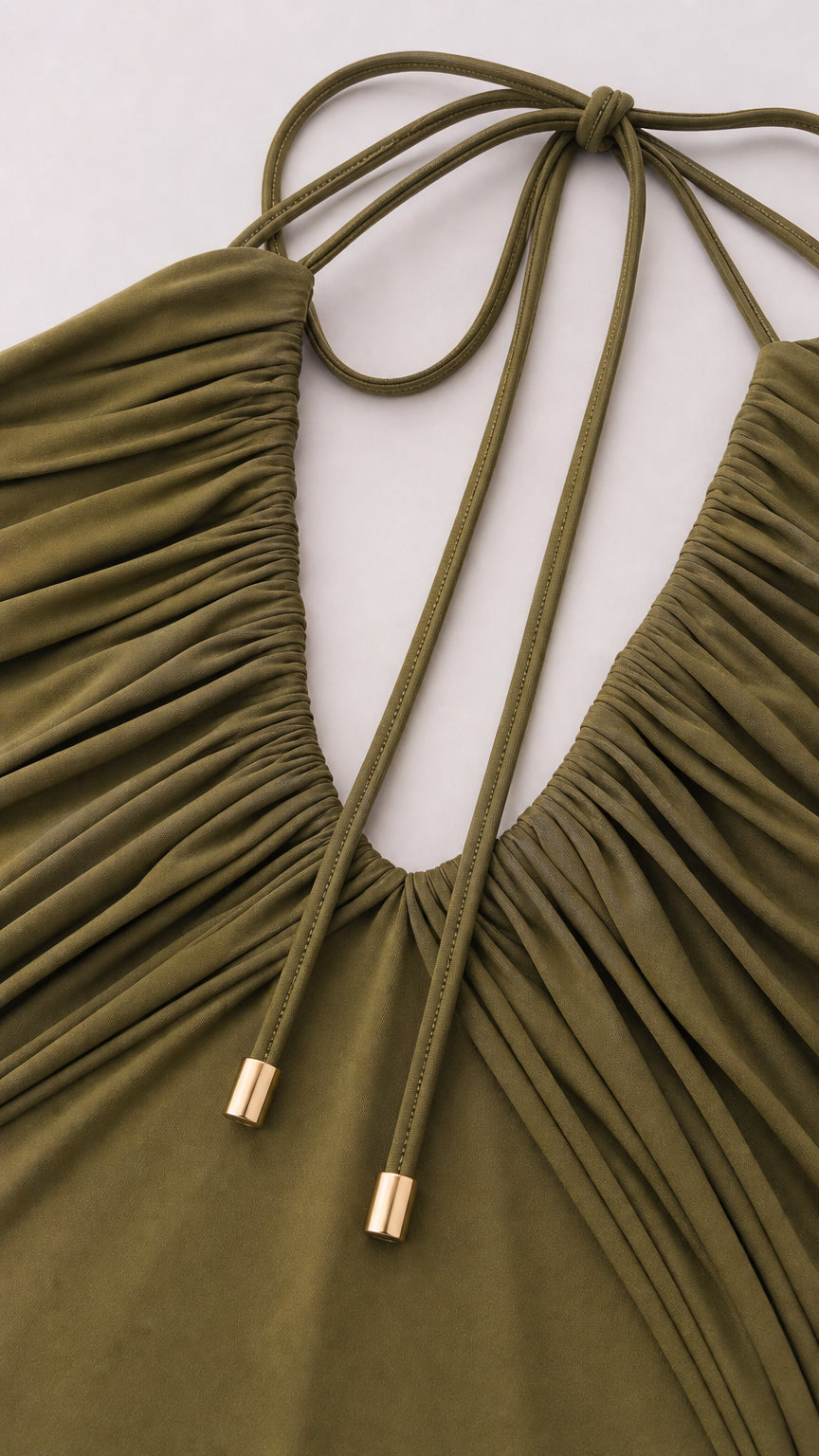 Close-up detail of pleated bust and halter ties with gold-tone hardware