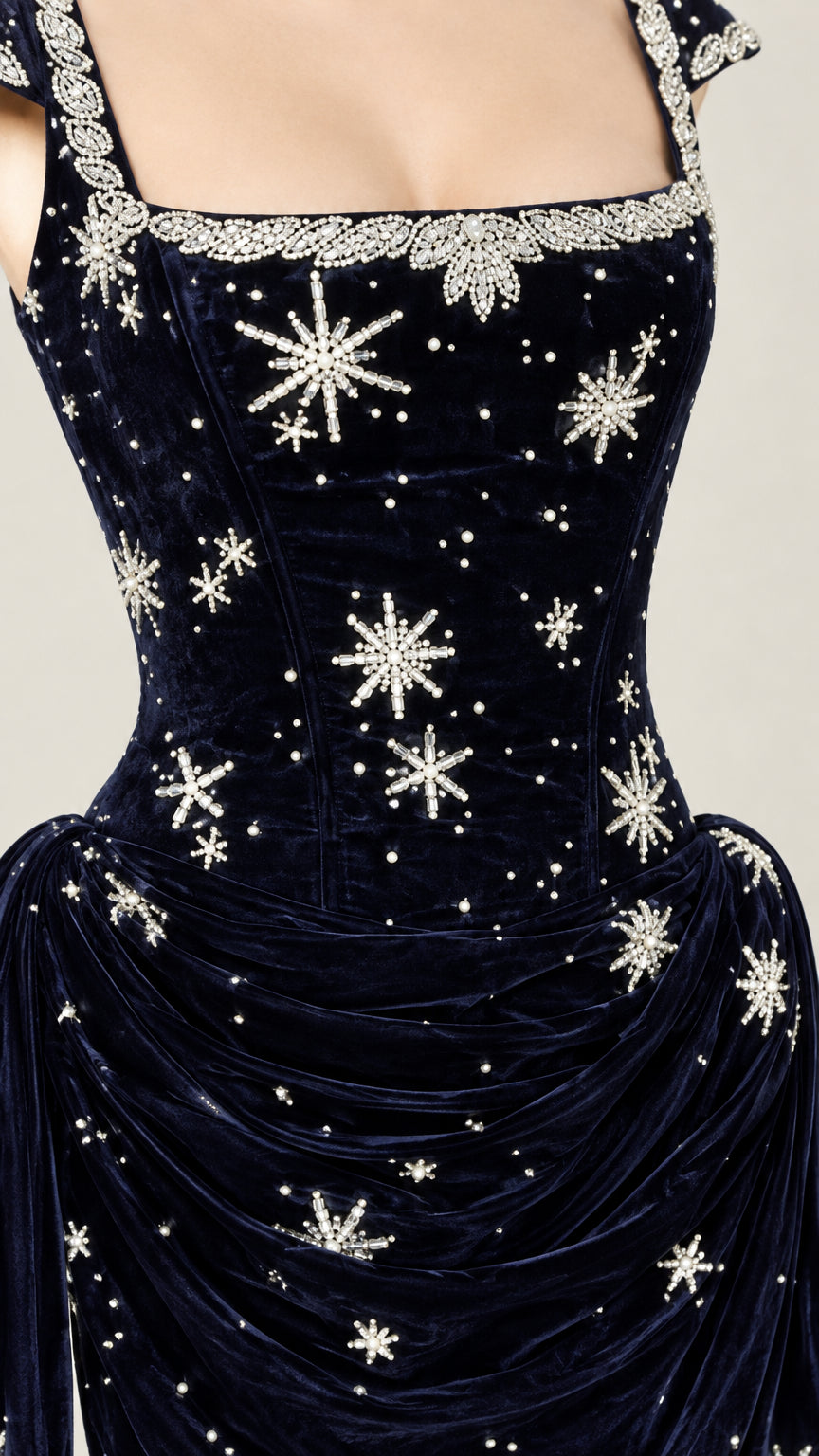 Close-up detail of embellished square neckline and draped waist on navy blue velvet gala gown