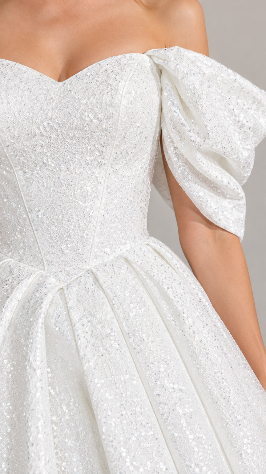 Close-up detail of the sweetheart neckline and glitter fabric of the white ball gown