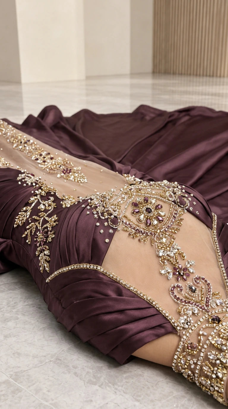 Close-up detail of sheer illusion bodice with crystal and metallic beadwork on burgundy satin