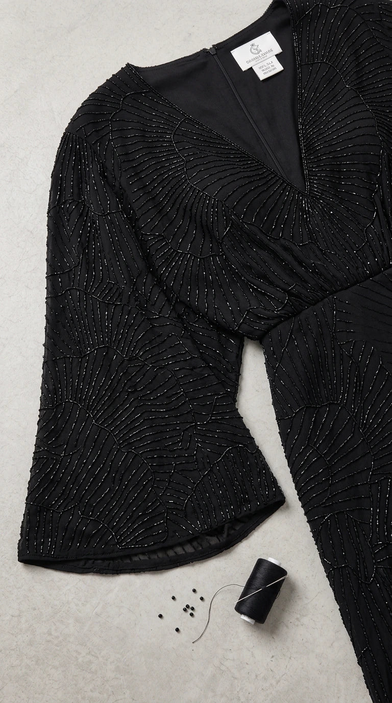 Close-up detail of black chevron beaded pattern on sheer sleeve with interior lining