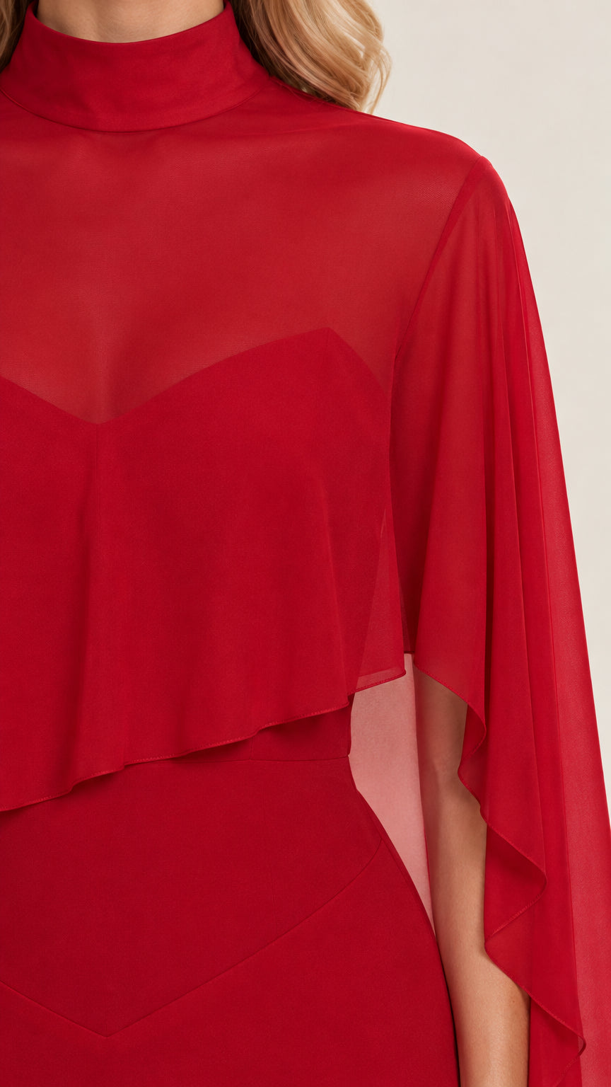 Close-up of high neckline and sheer capelet overlay on red gown