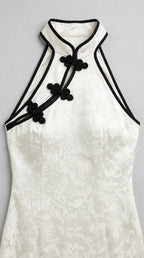 Close up of mandarin halter neckline, contrast black trim, and floral jacquard weave