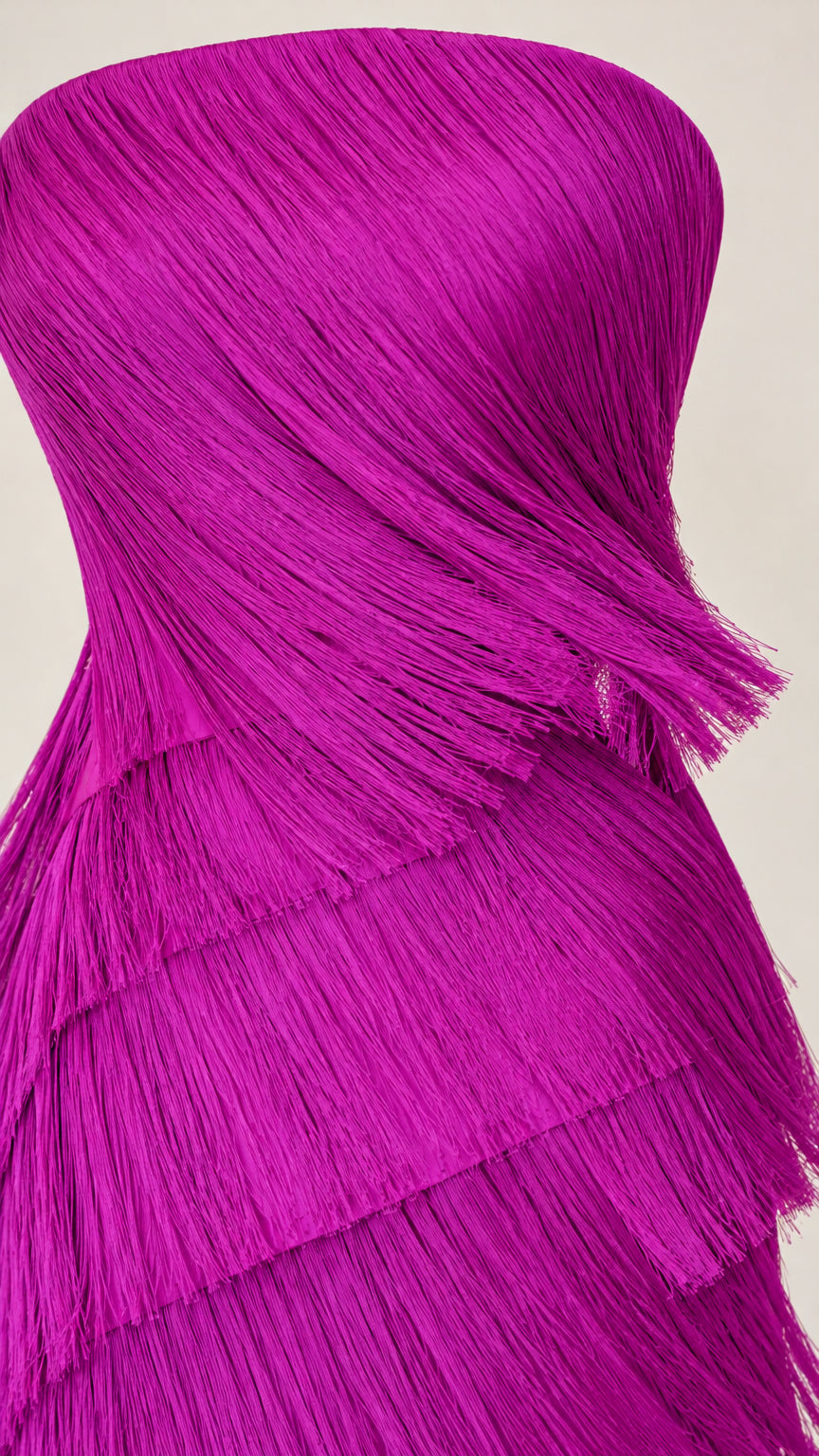 Close-up detail of textured diagonal fringe layers on magenta evening dress