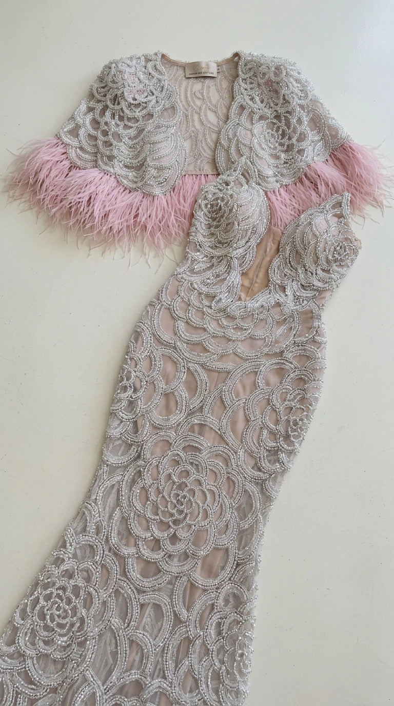 Flat lay of silver beaded evening gown and feather capelet set