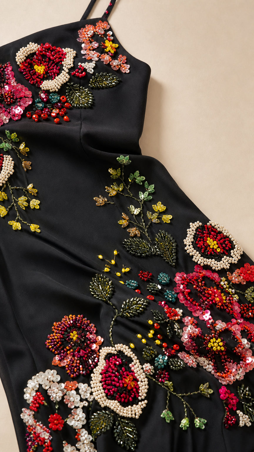 Close-up detail of multi-colored floral beading and sequins on black formal gown fabric