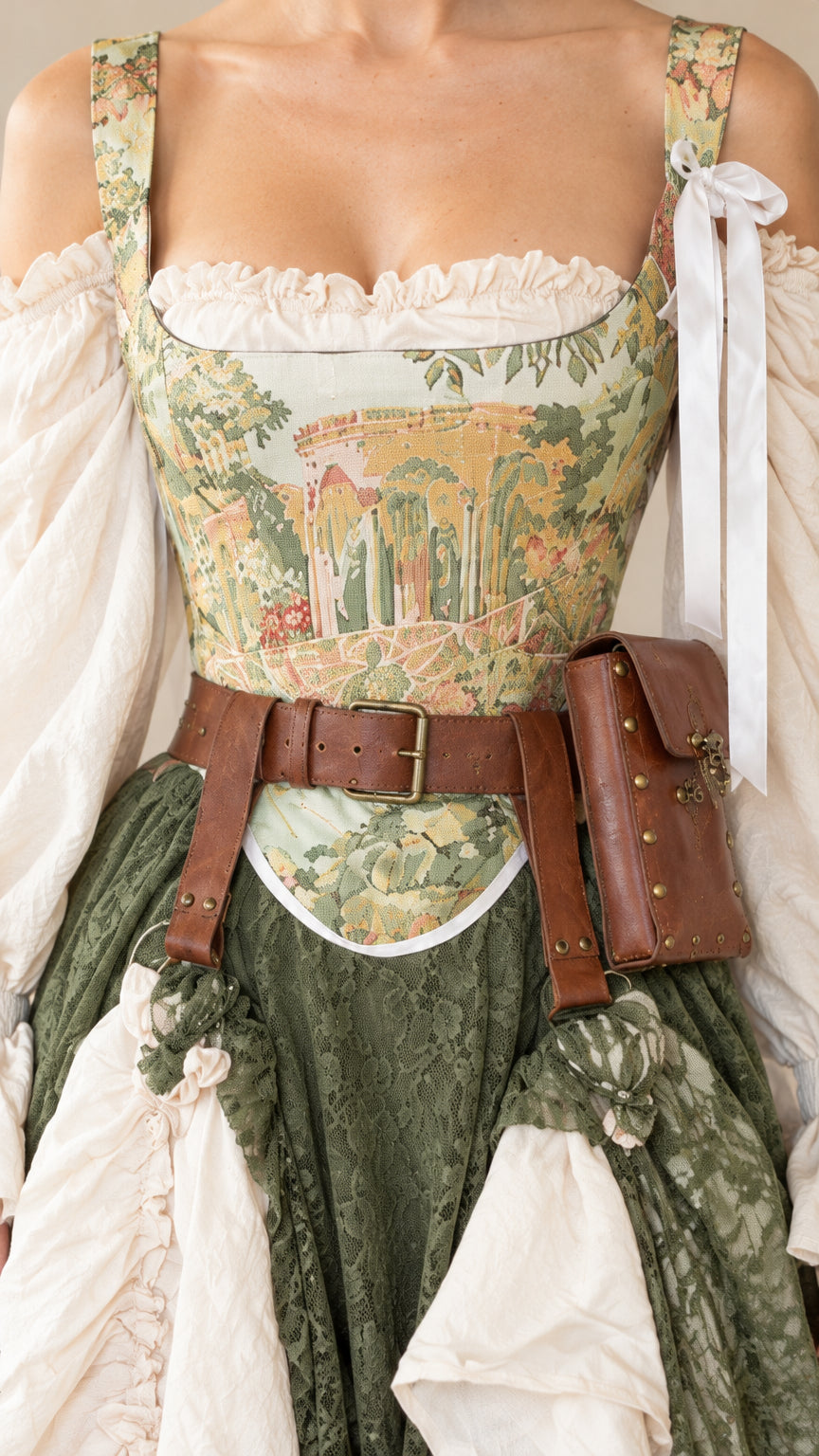 Close-up detail of tapestry landscape corset bodice with ribbon shoulder ties and waist belt accessory
