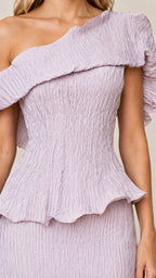 Close-up detail of lilac crinkle texture and asymmetric ruffled neckline