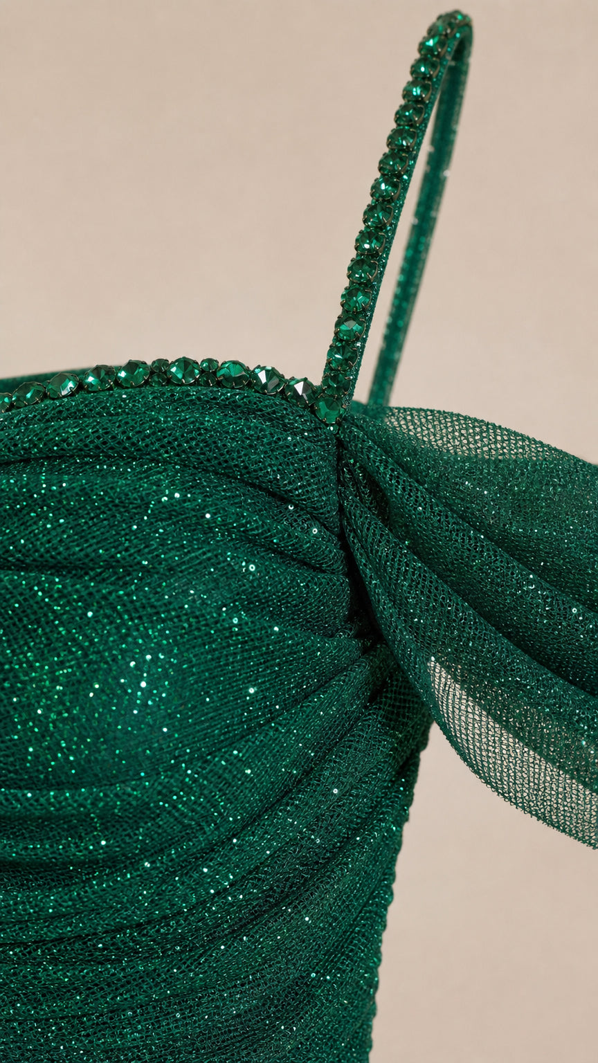 Close-up detail of beaded strap and shimmering ruched mesh fabric on the emerald green gown