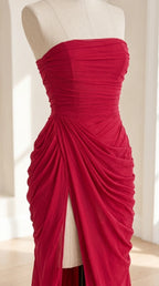 Close-up mannequin view showing the gathered ruching and high slit on magenta strapless gown