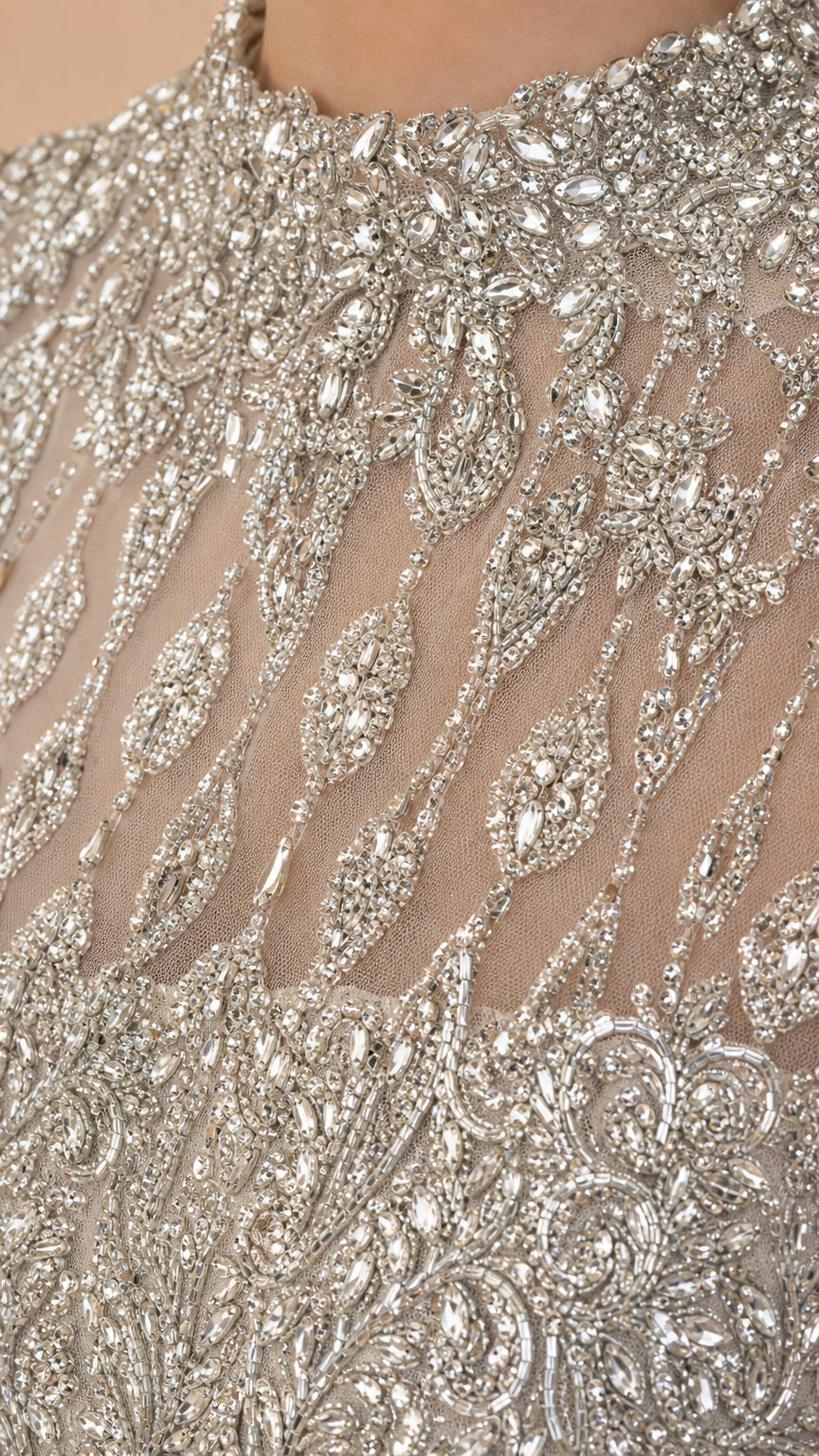 Close-up detail of intricate crystal and bead embroidery on sheer mesh